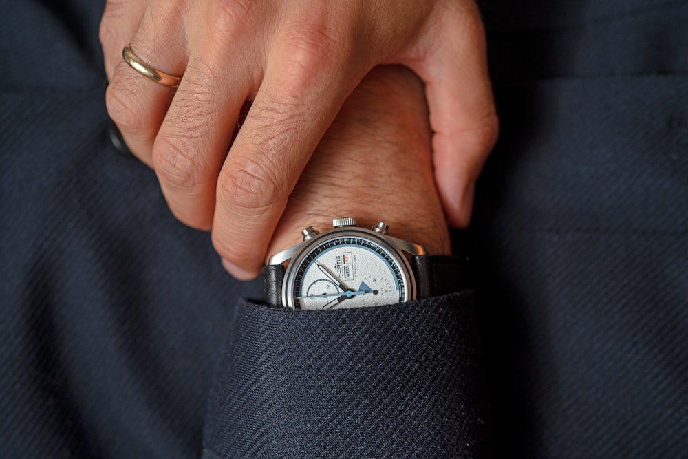 a person's hand holding a watch