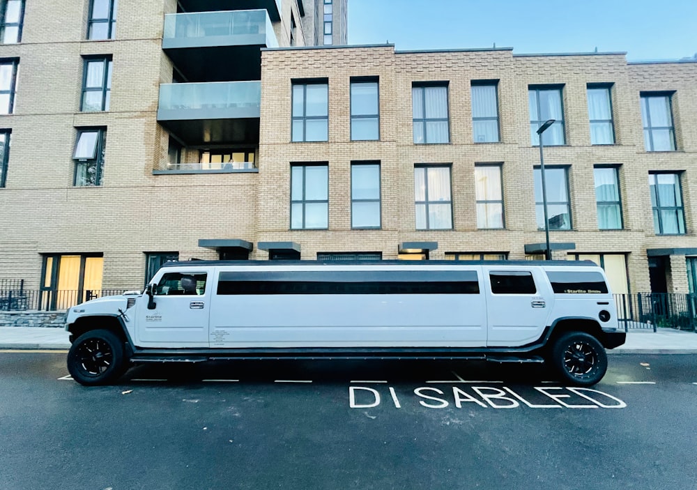 Una limusina blanca estacionada frente a un edificio