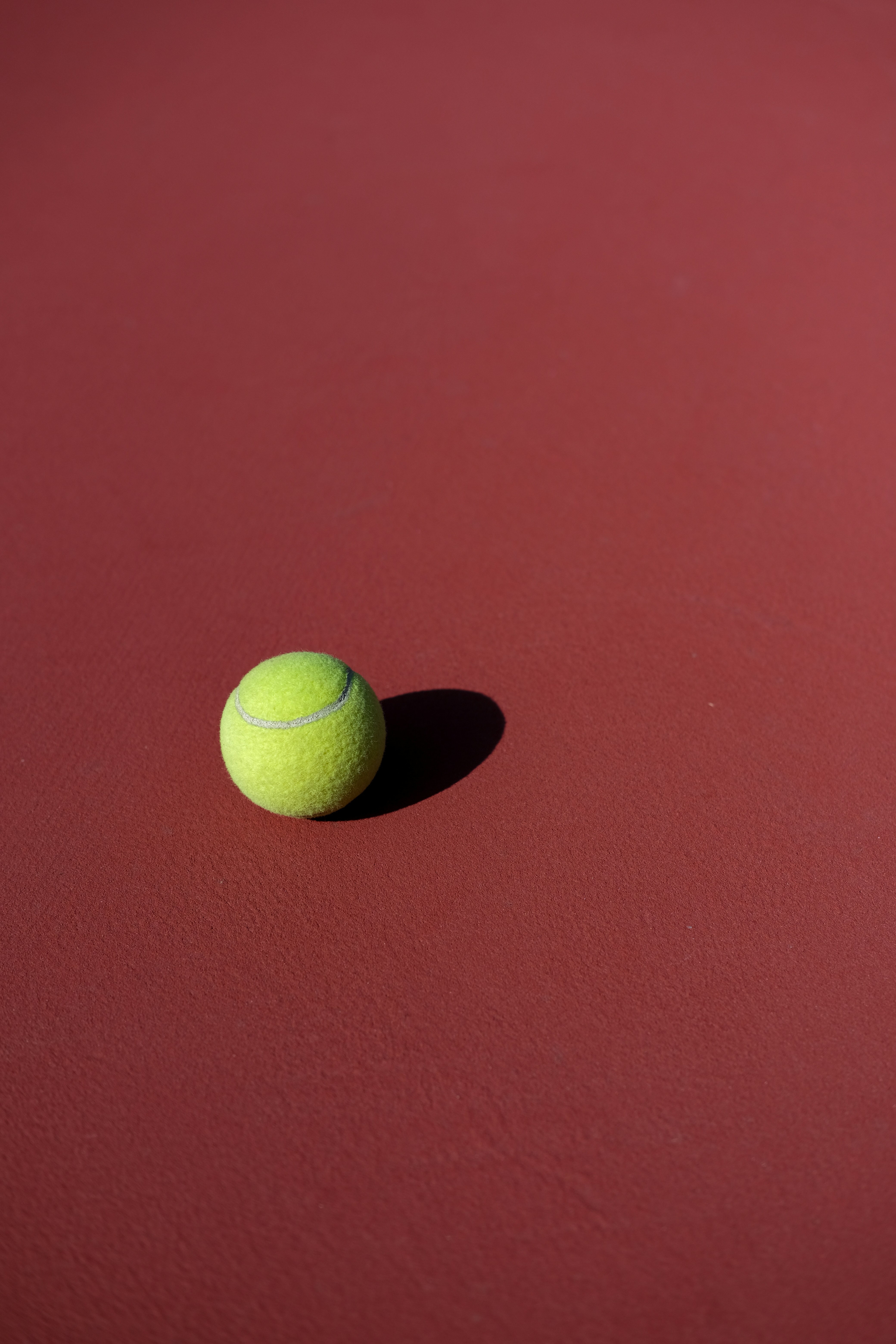 a tennis ball on a red surface