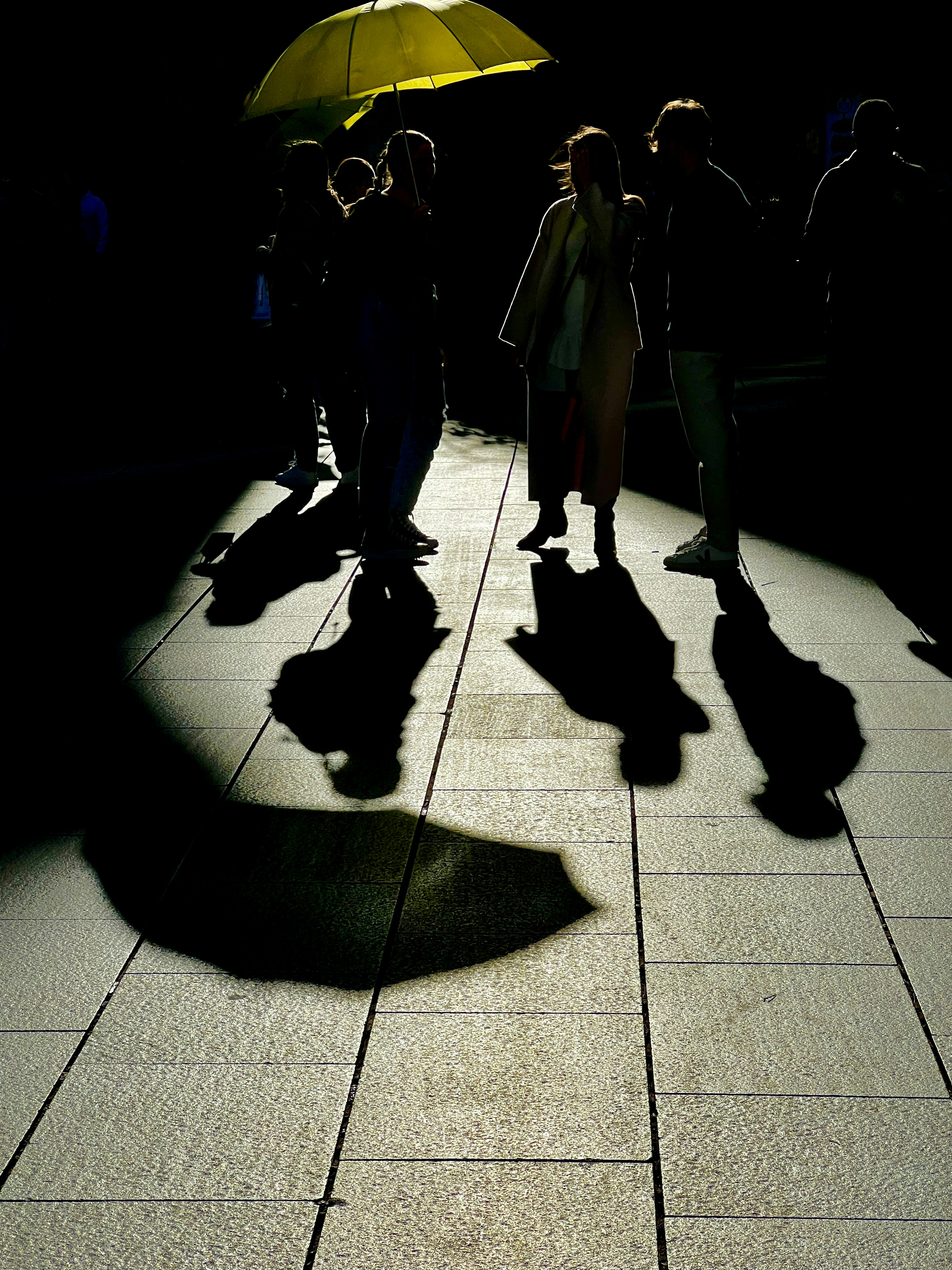 a group of people walk down a sidewalk