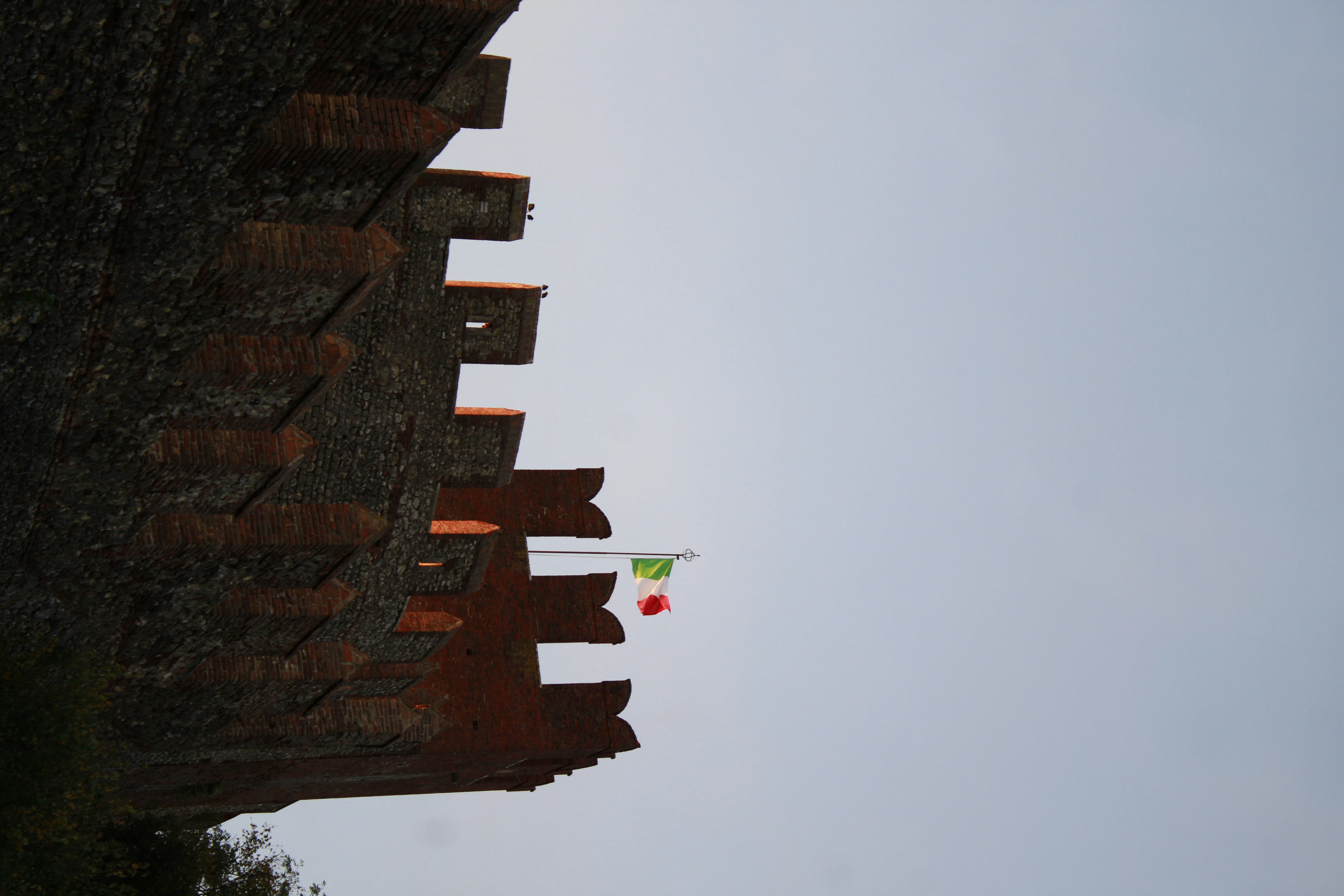 Un bâtiment en briques avec des drapeaux sur le dessus
