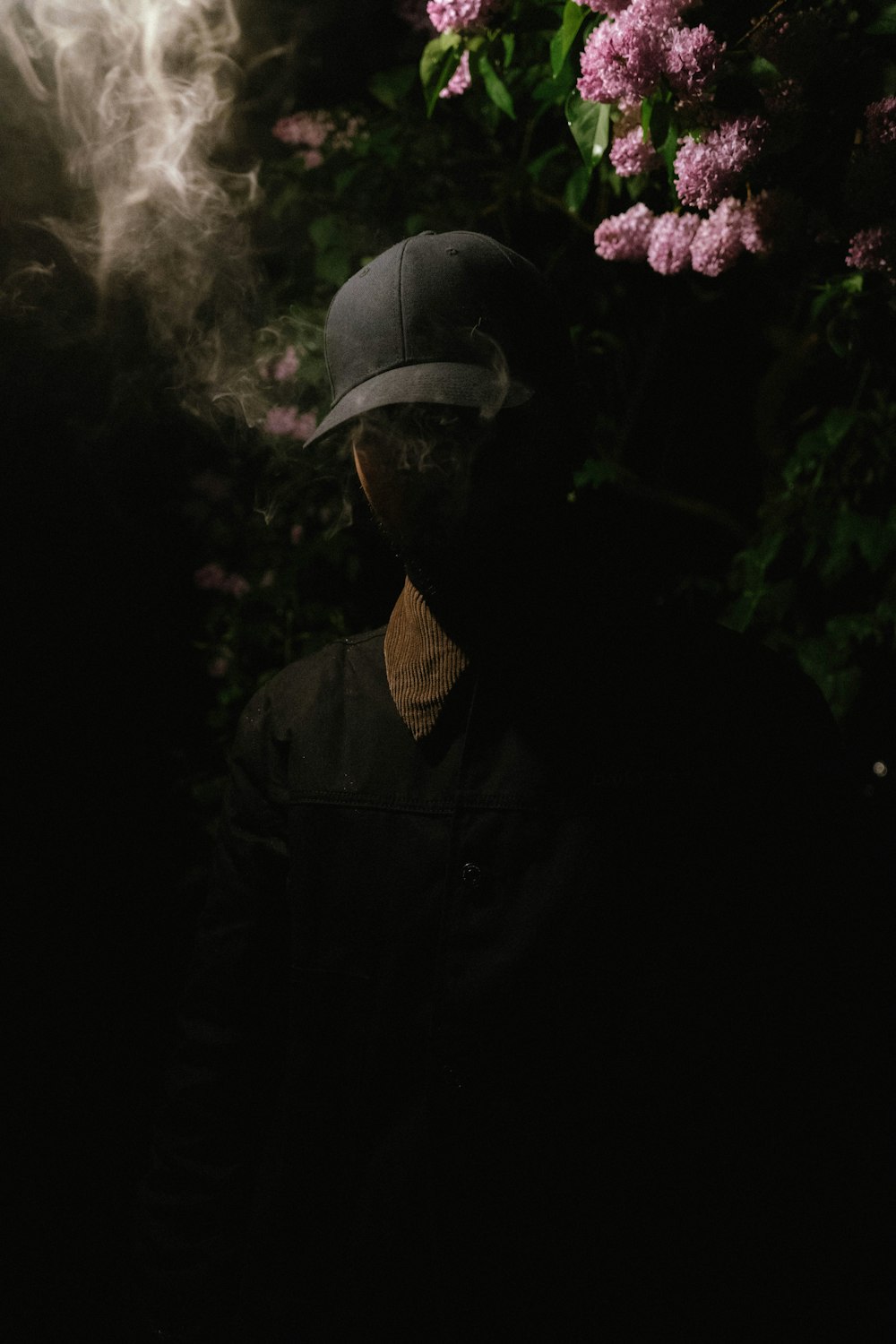 a man wearing a hat and smoking a cigarette