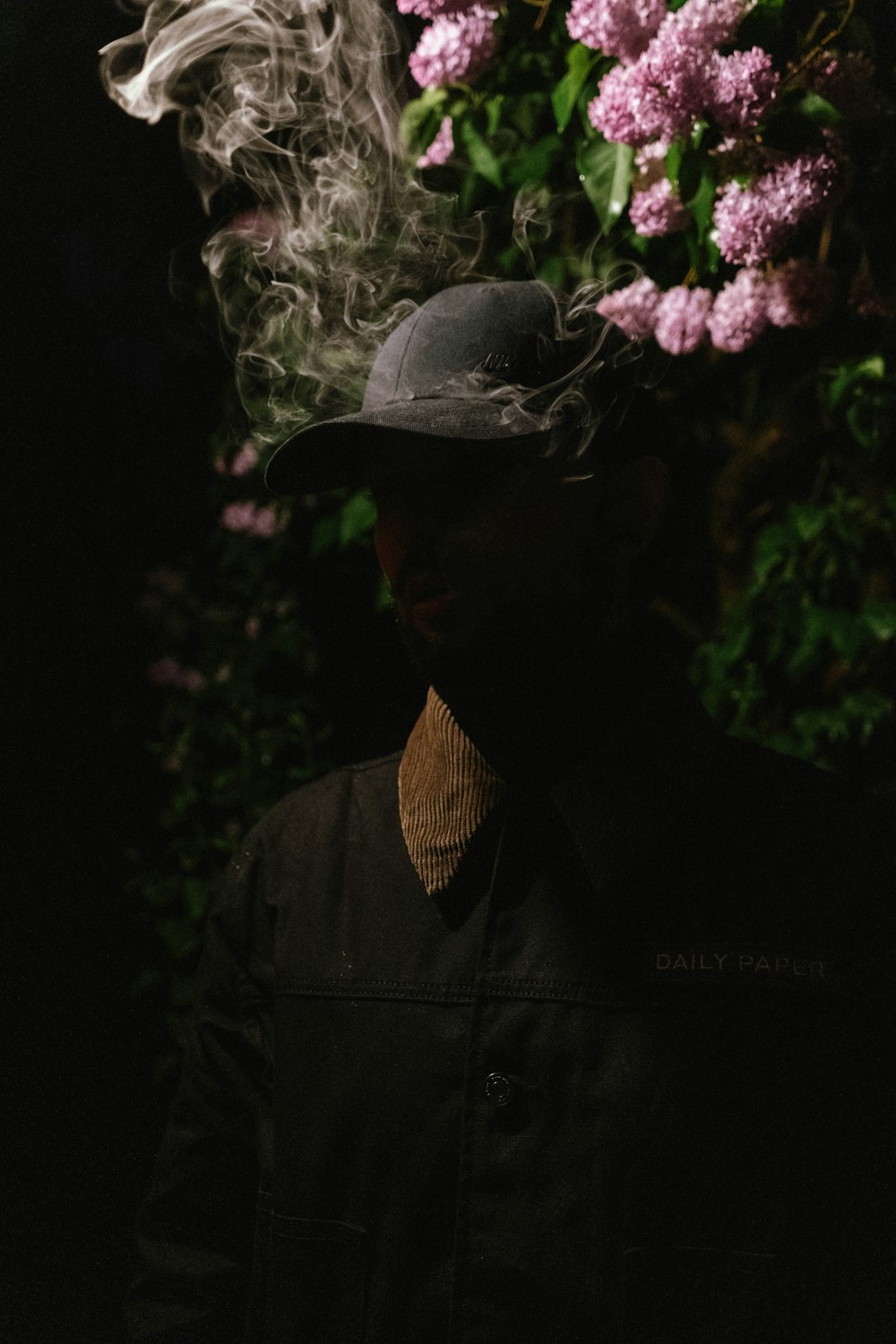 a person wearing a hat and holding a bouquet of flowers