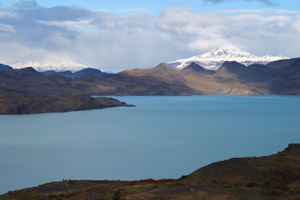 a body of water with mountains in the background