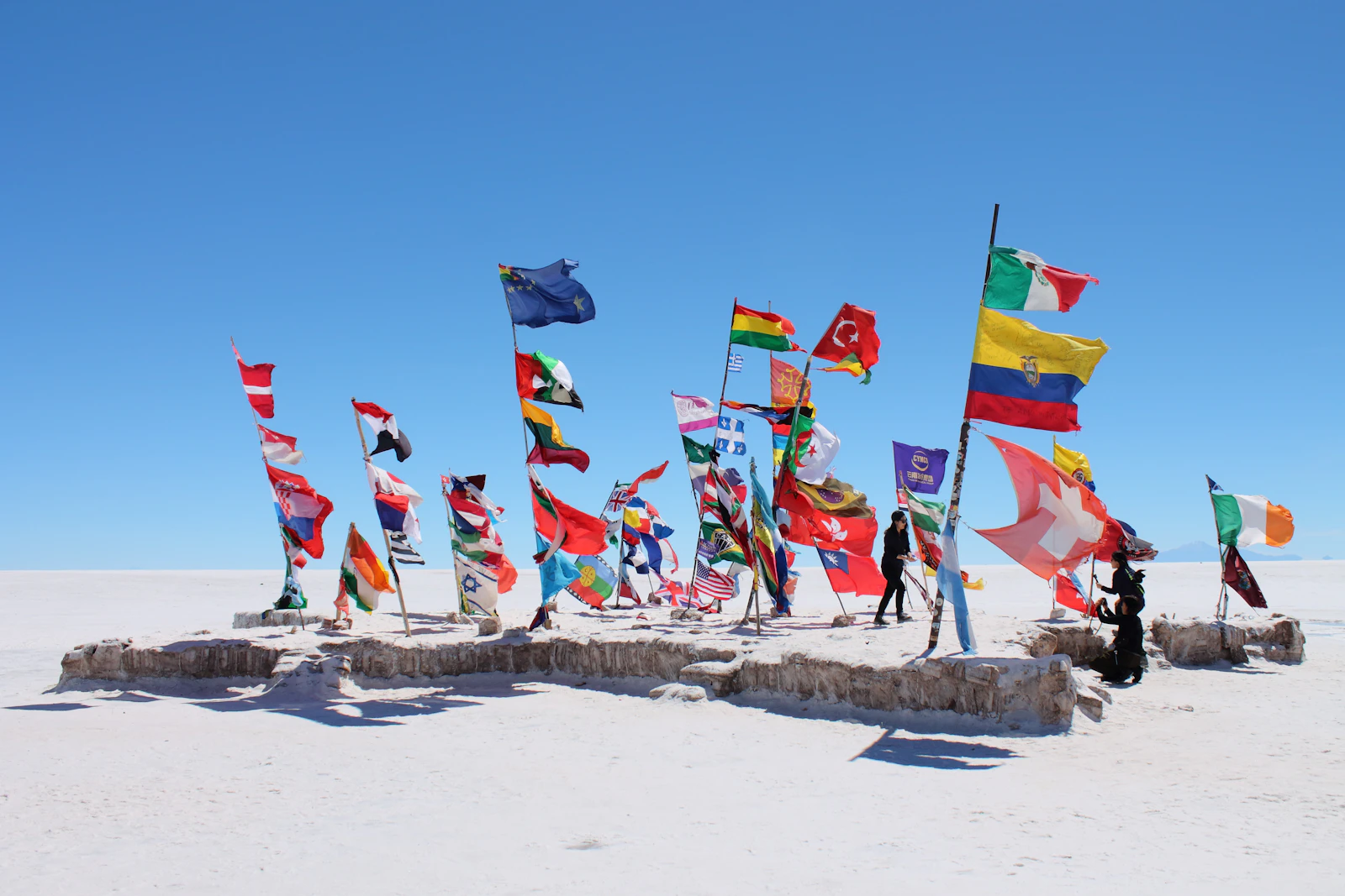 Banderas internacionales en el paisaje blanco del Salar de Uyuni, Bolivia