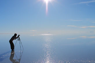 a man standing on a rock in the water with a camera