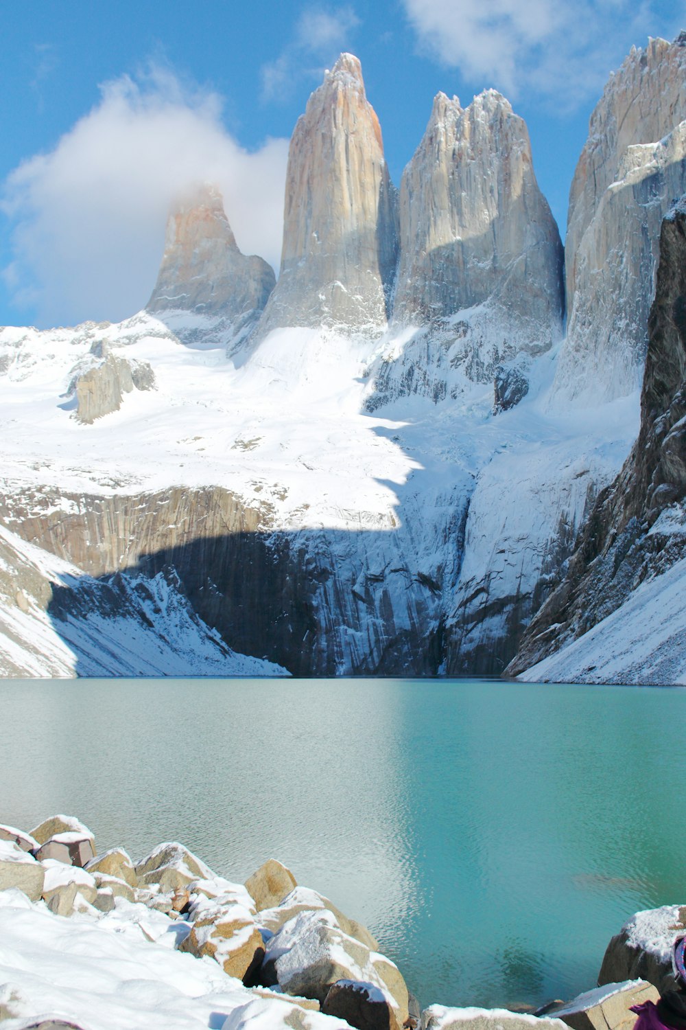 a body of water with snow and mountains in the background