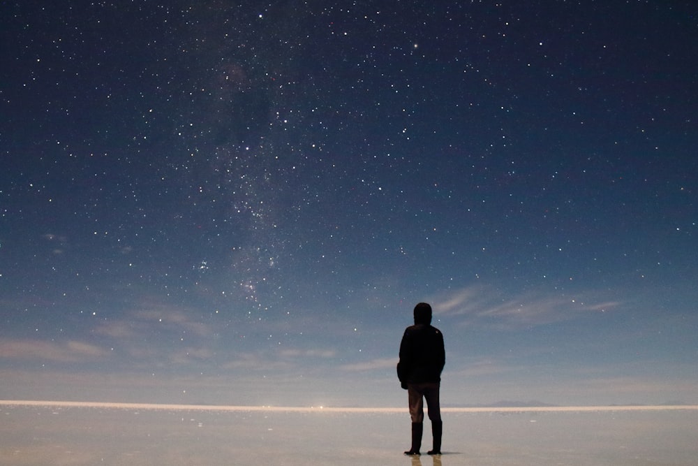 Ein Mann steht auf einem Feld mit Sternen am Himmel