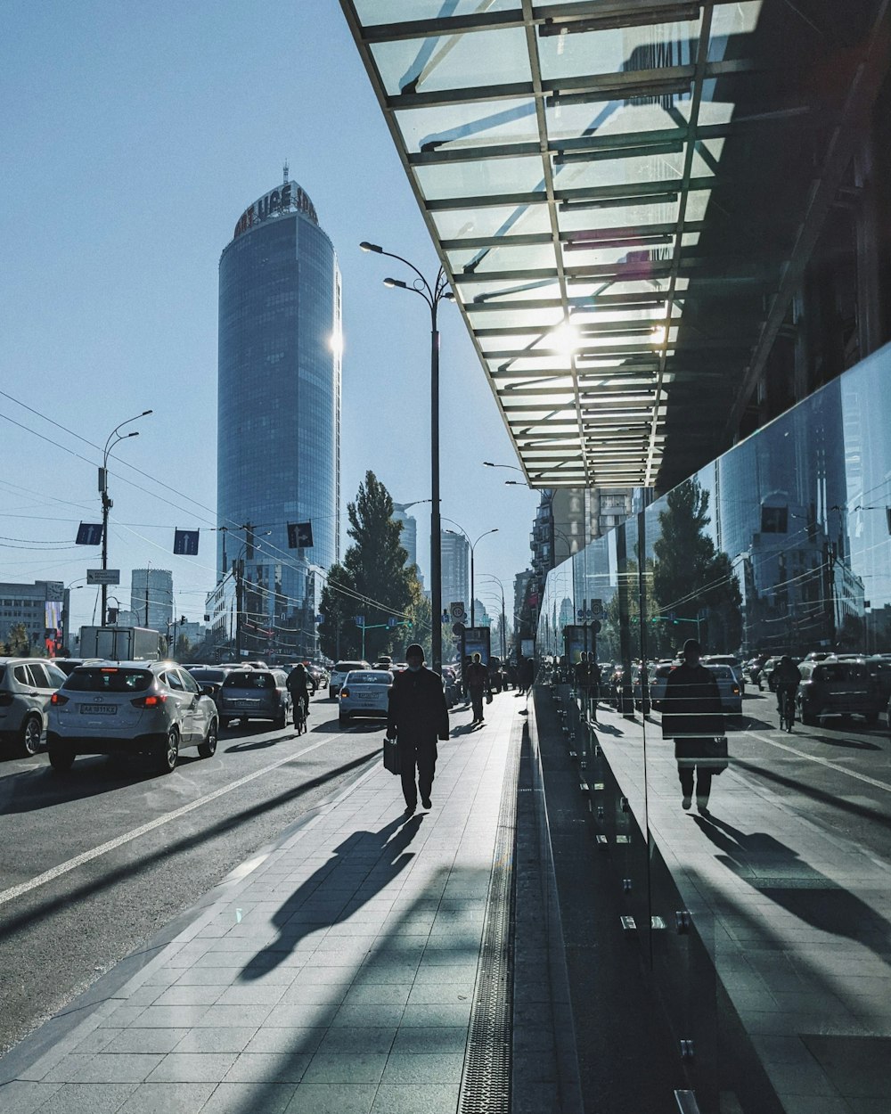 a street with cars and people on it and buildings in the back