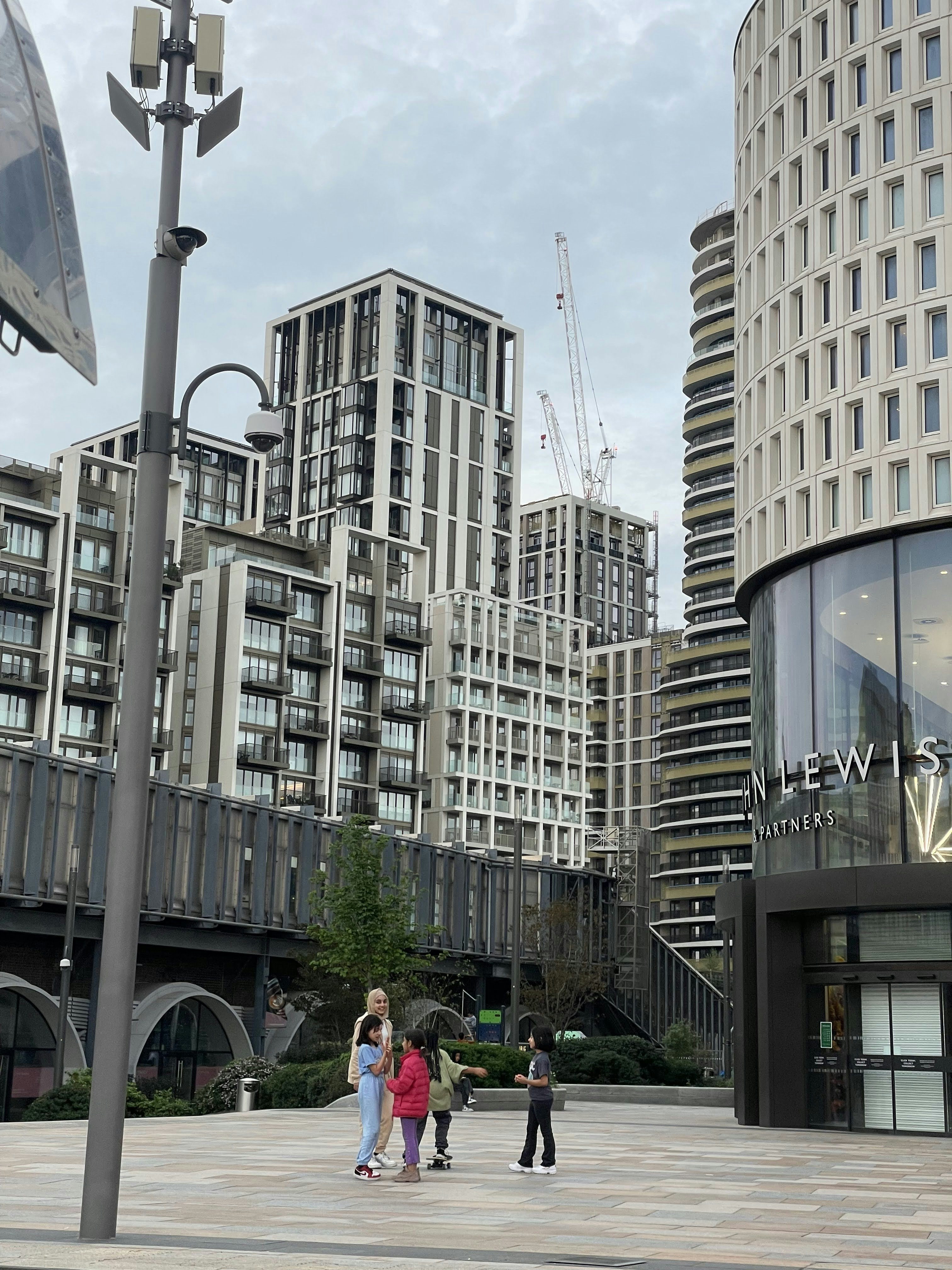 a group of people walking on a sidewalk in front of a building