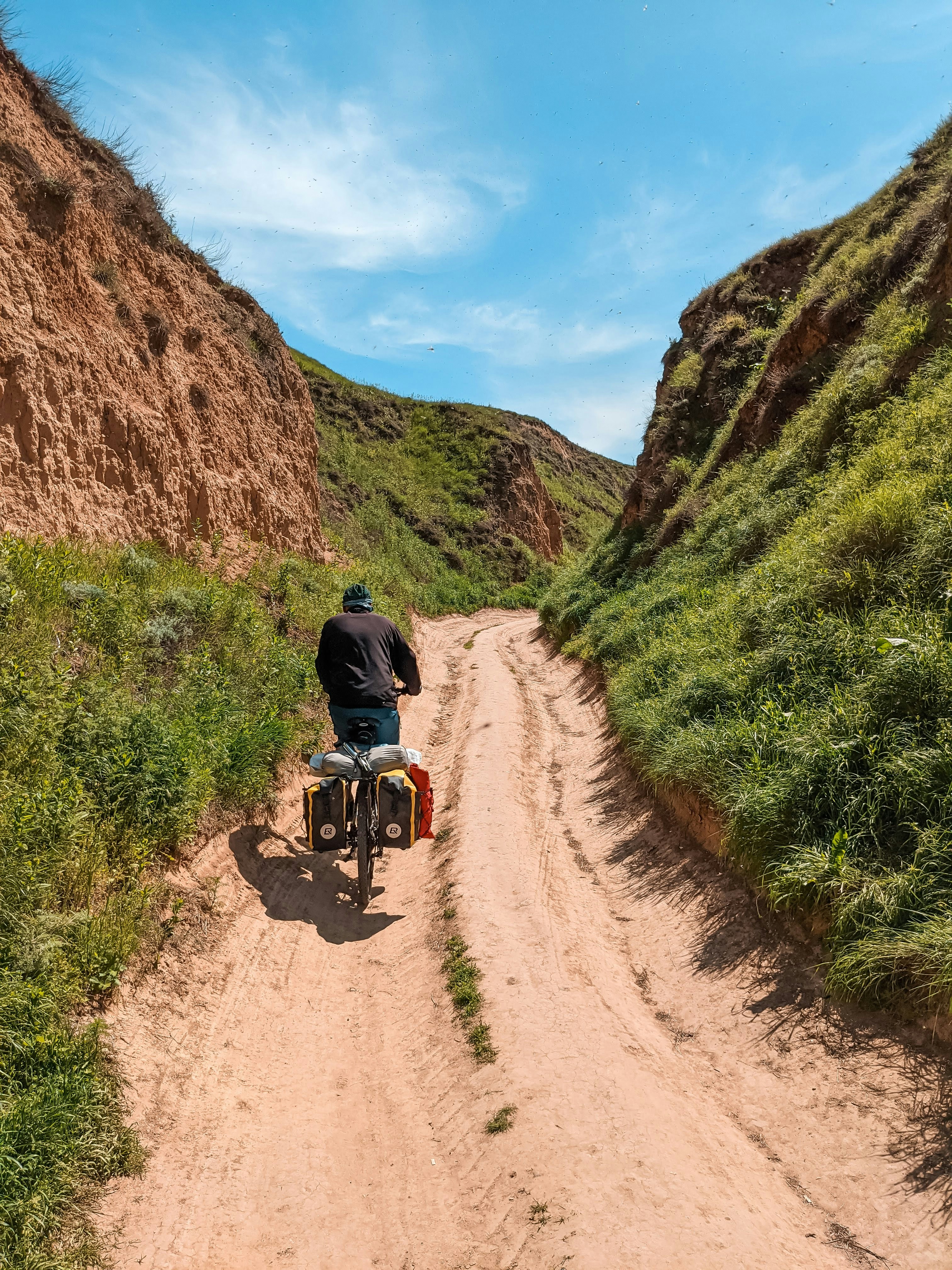 Ein Mann auf einem Motorrad auf einem Feldweg zwischen Bergen