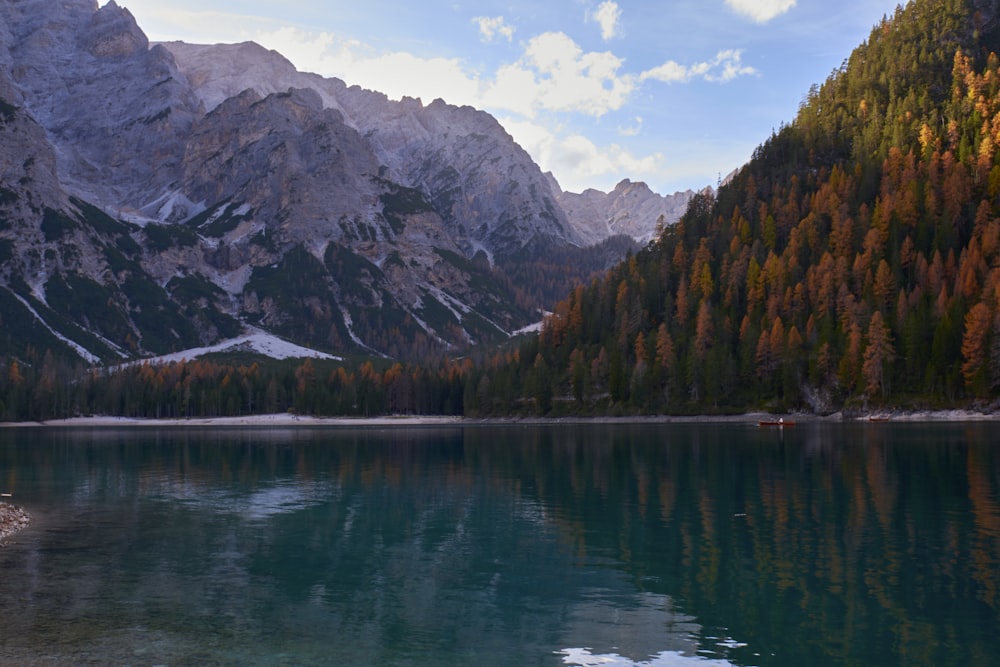 a lake with trees and mountains in the background