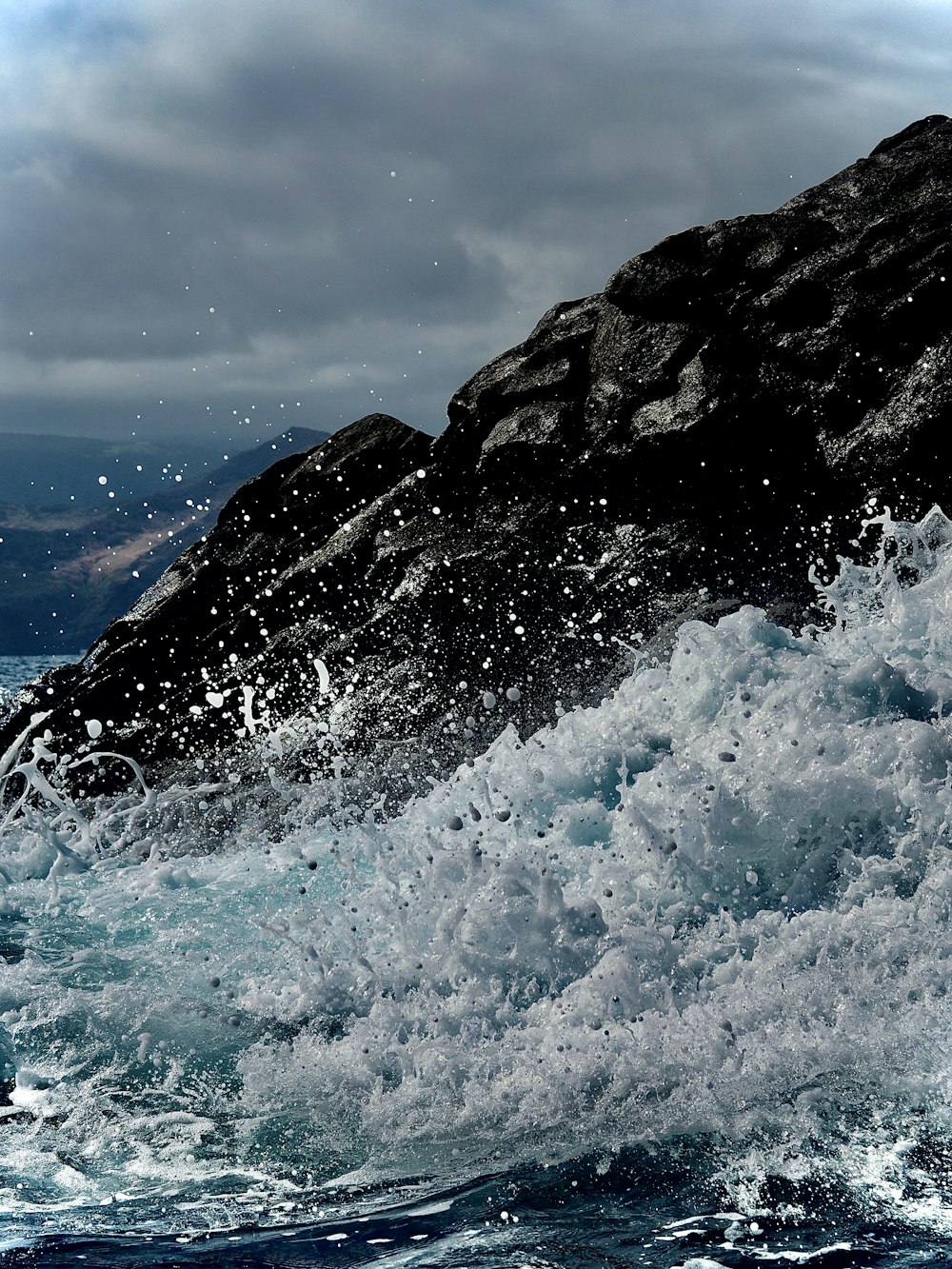 a wave crashing against a cliff