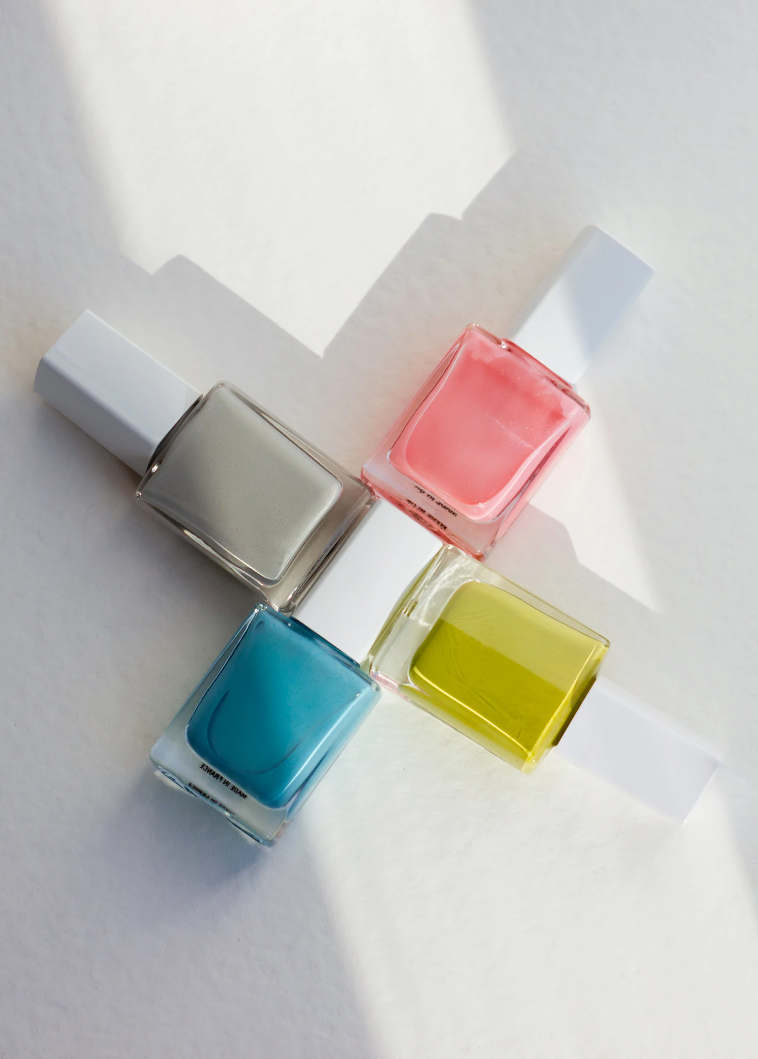 Pearlhand Shimmer Polish, four square glass polish bottles laid out in hard sunlight — in stock