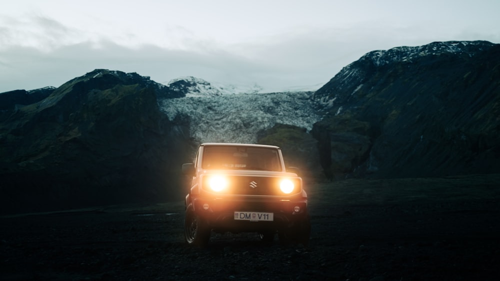 a car parked in a dark area with mountains in the back