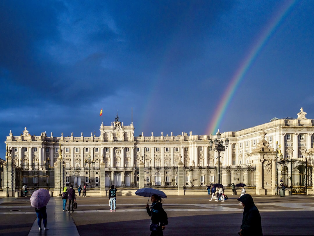 a large white building with a rainbow in the sky,