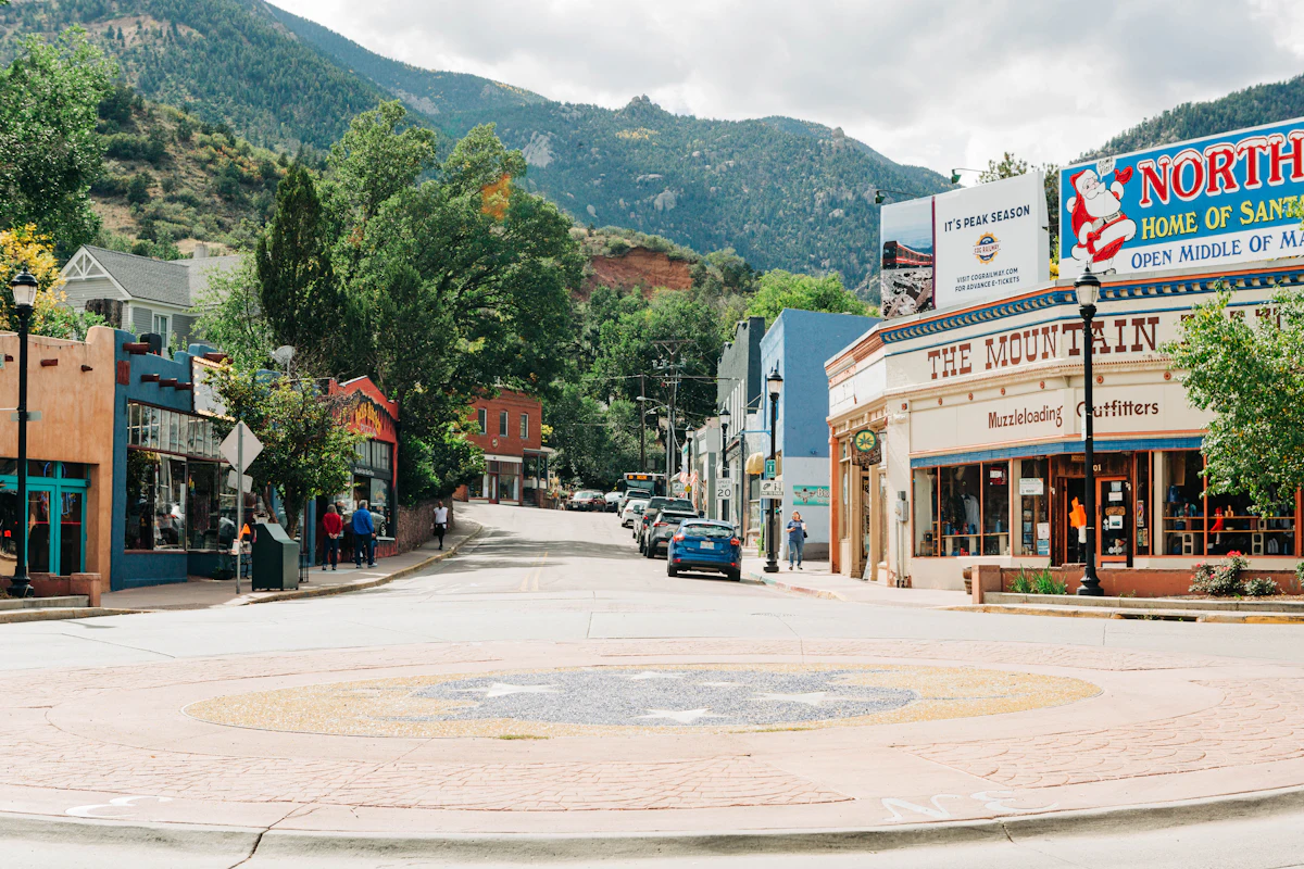 A street of shops in Manitou Springs, with wooded foothills rising behind