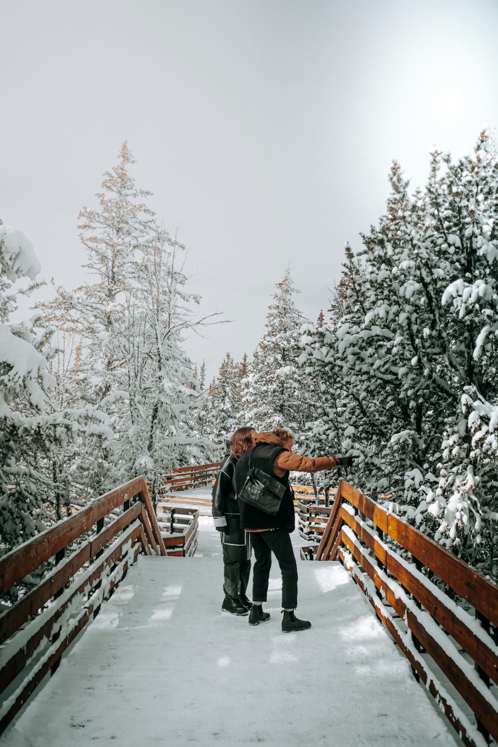 a man standing on a bridge with snow on the ground