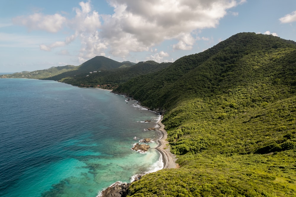 une plage avec un plan d’eau et des collines autour d’elle