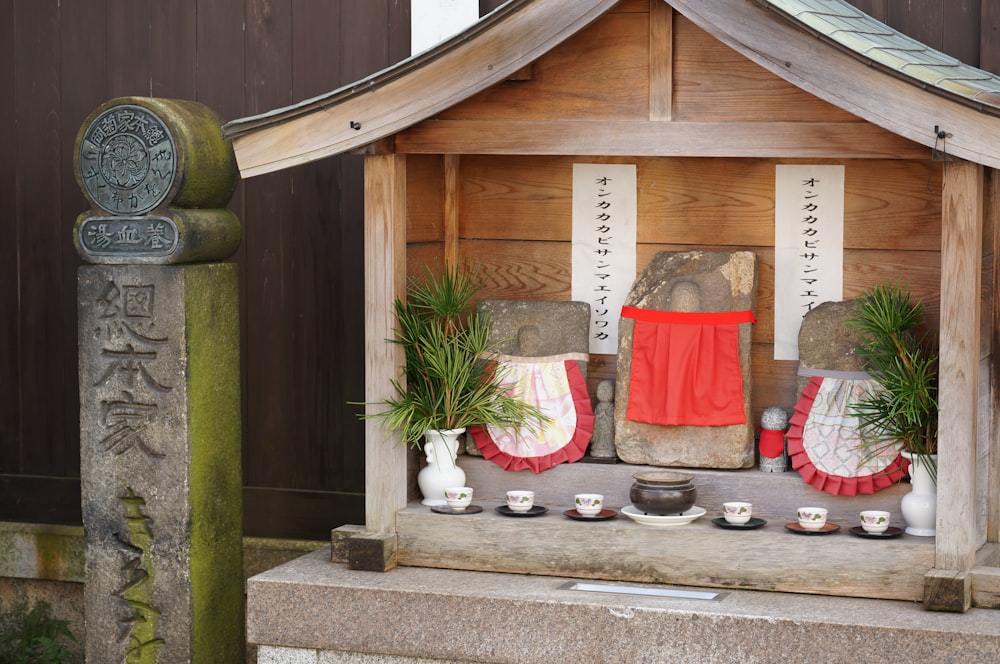 a wooden cabin with a few chairs and plants