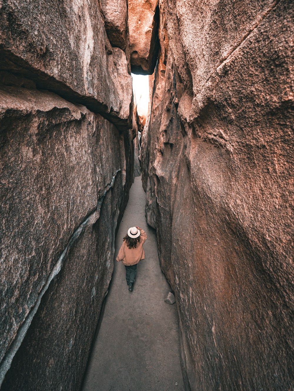 a person standing in a narrow canyon