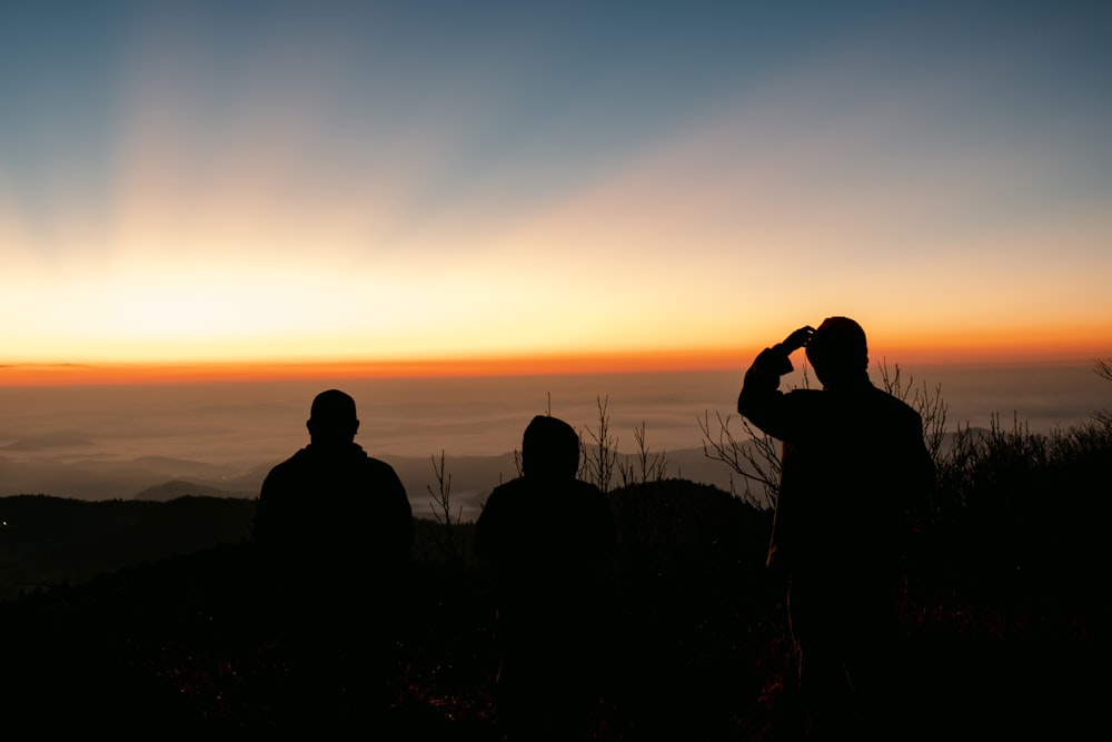 a group of people taking a picture of the sunset