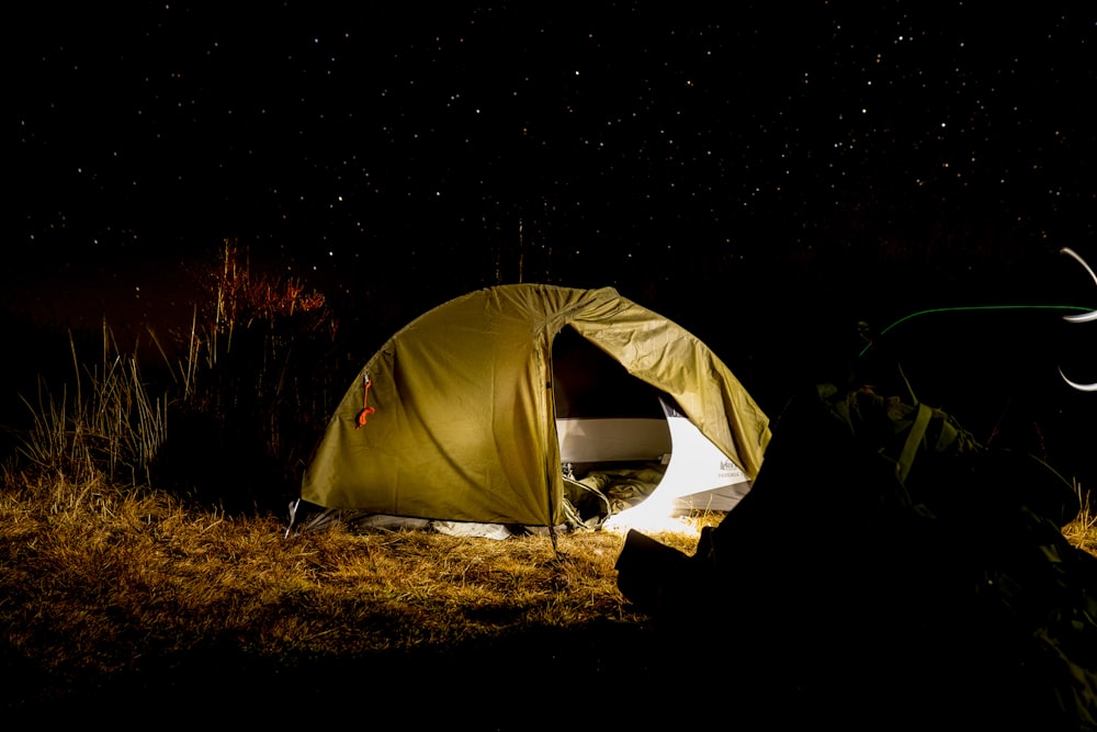 uma pessoa deitada em uma tenda à noite