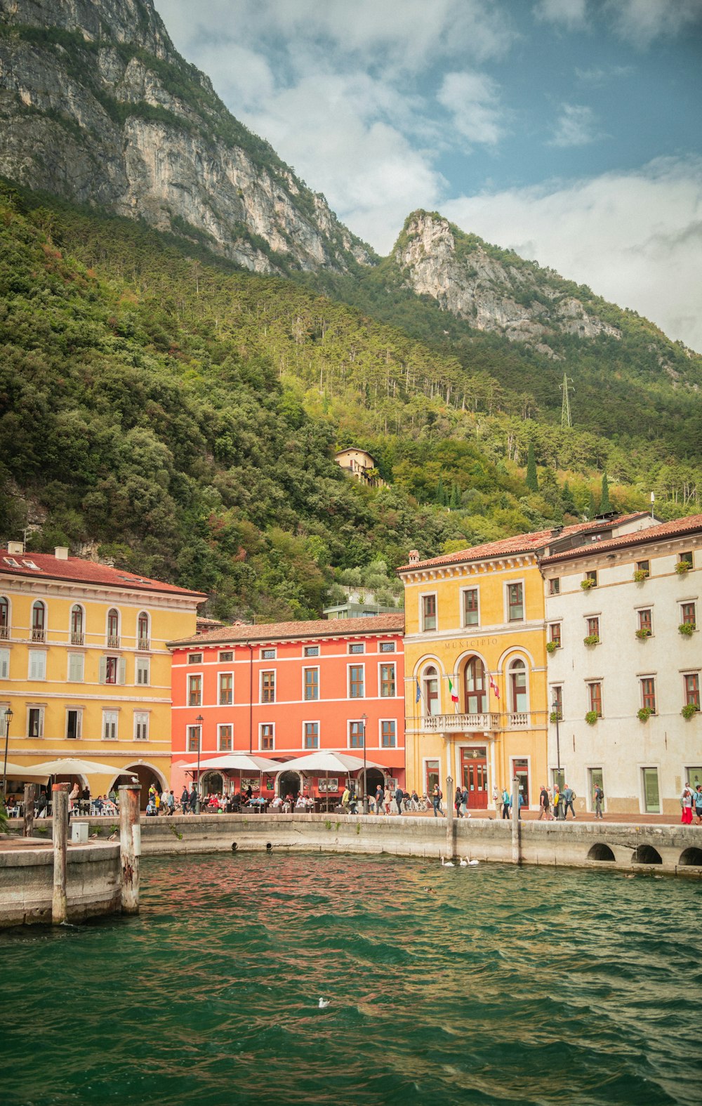 a body of water with buildings and a mountain in the background