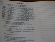 A close-up view of an open book showing text from Ecclesiastes 4:1. The text is typed in a serif font, and the page features numbered verses with a visible heading. The content discusses the human condition and philosophical reflections. The lighting is soft, casting slight shadows.