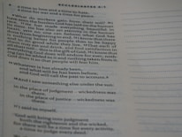 A close-up of a page from a book, specifically a biblical text from Ecclesiastes, featuring text highlighted with verse numbers. The text discusses philosophical reflections on life and human existence.