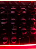 Array of tactical helmets lined up on a metal rack under soft lighting.