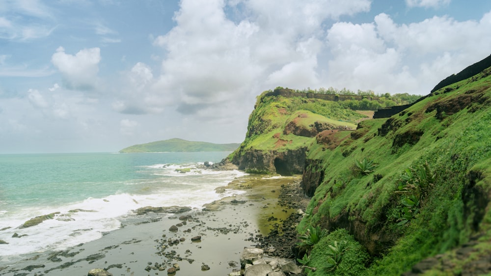 a beach with a hill and water