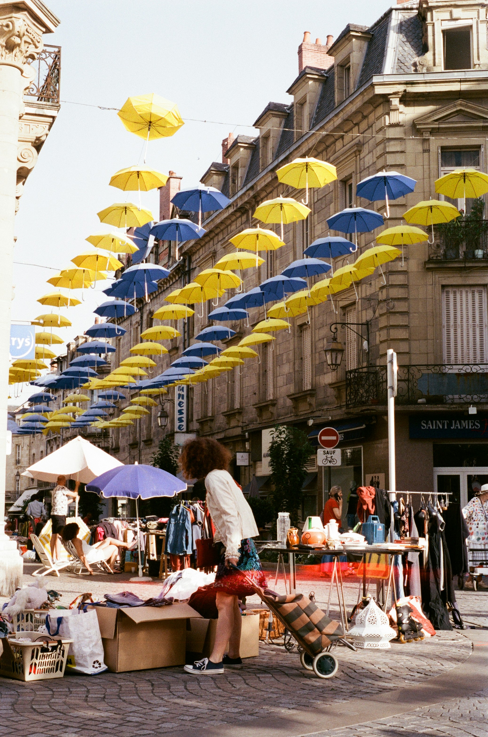 People sitting on a bench under umbrellas - paris flea markets vintage