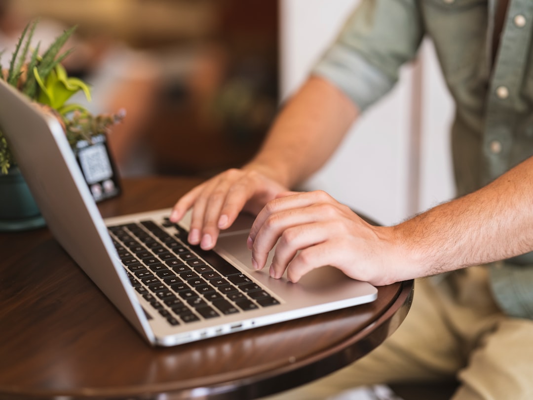a man typing on a laptop, a man working with laptop at the table