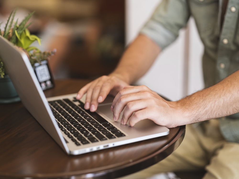 a man typing on a laptop