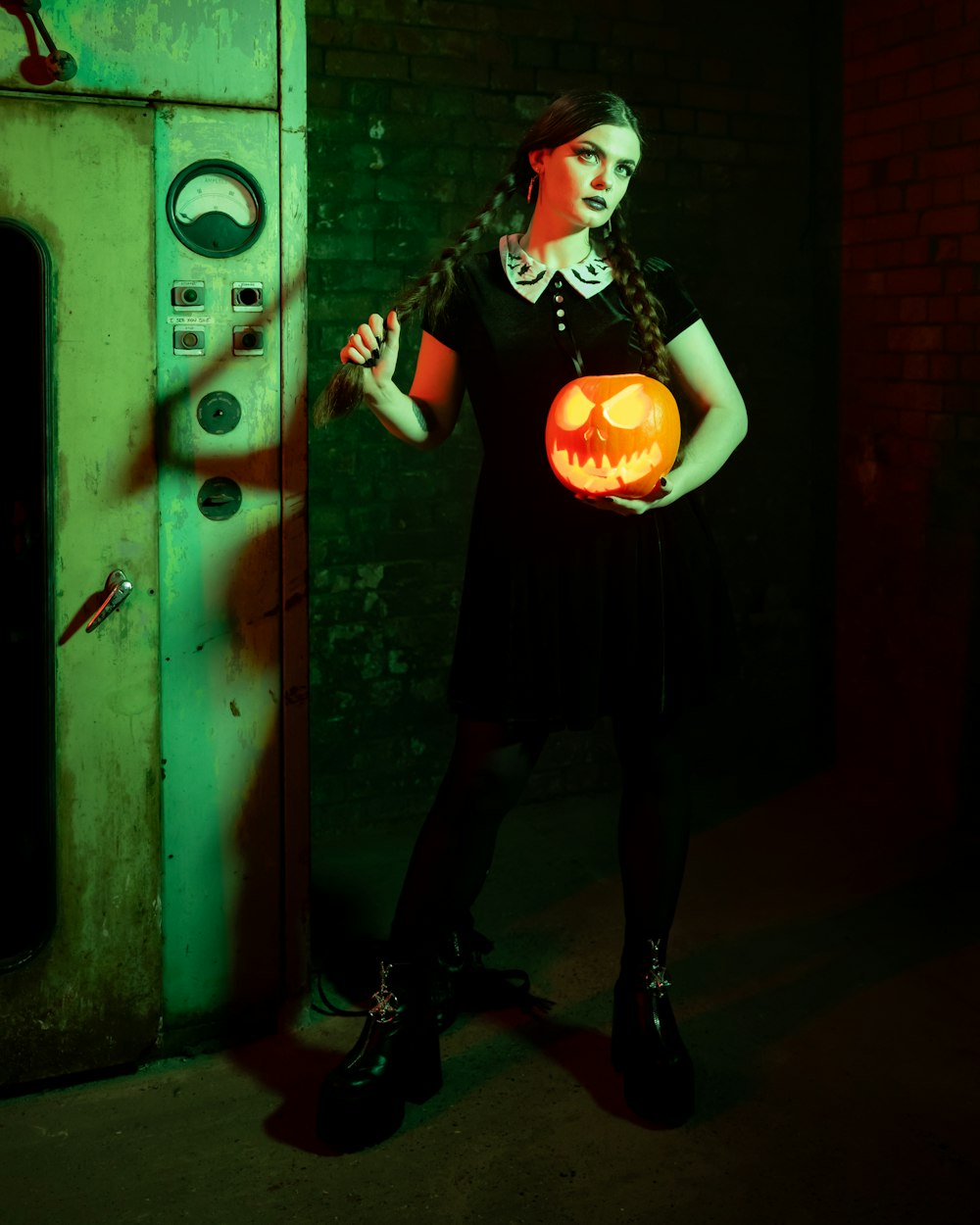 a person wearing a black dress and holding a pumpkin