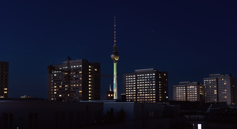 Stadtansicht bei Nacht mit beleuchtetem Turm