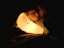 A child smiling in bed under the gentle glow of the rotating star projector lamp.