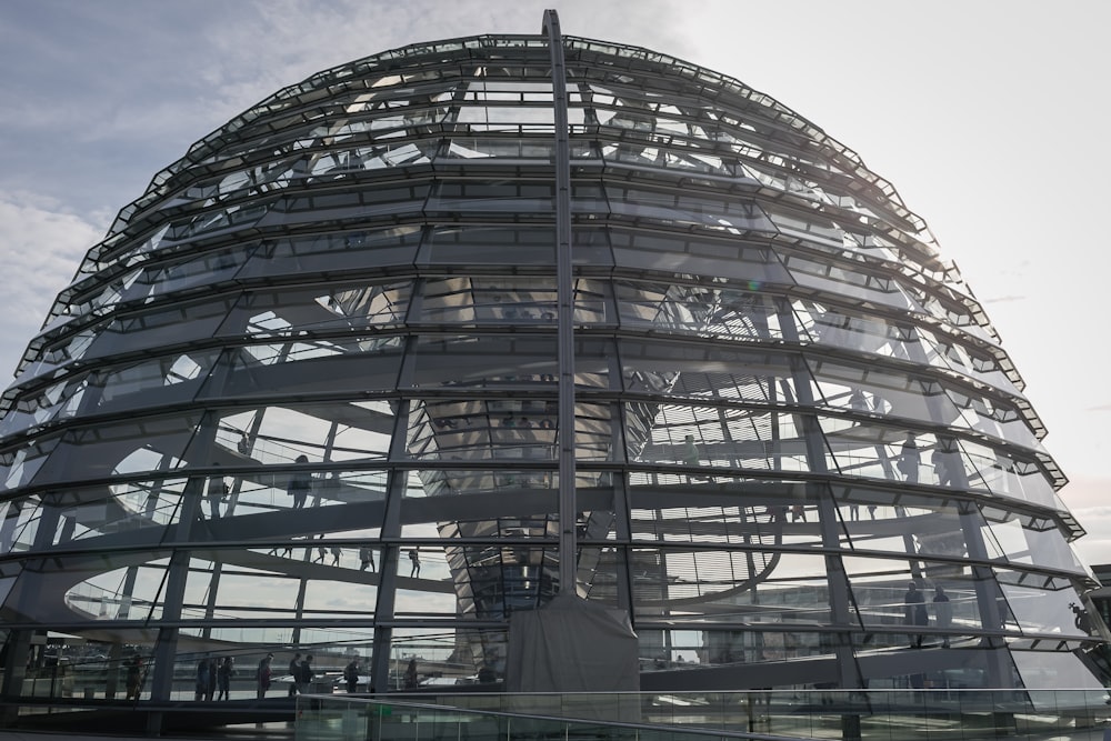ein großes Glasgebäude mit Reichstagskuppel im Hintergrund