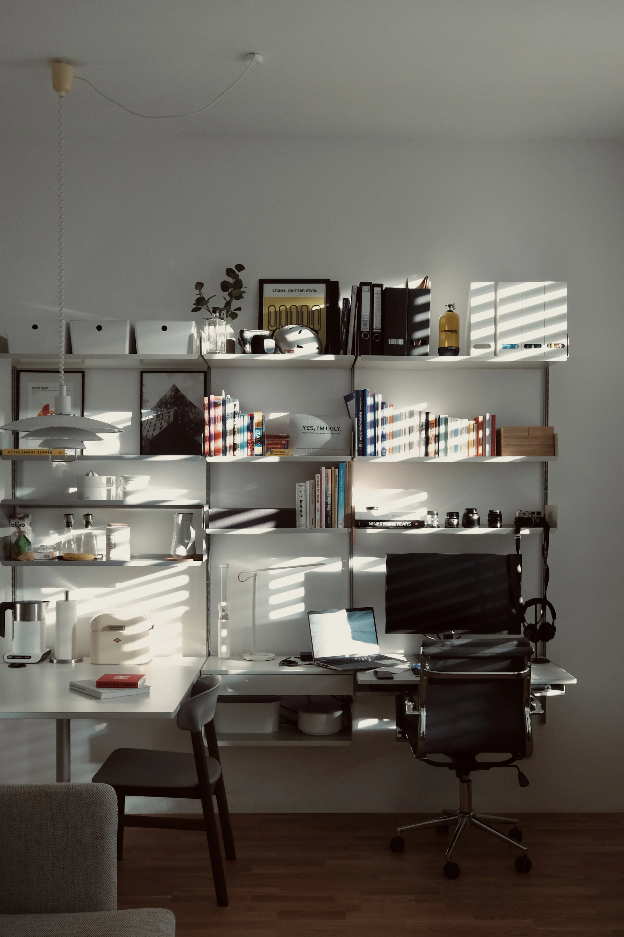 A quiet desk with a laptop against shelves
