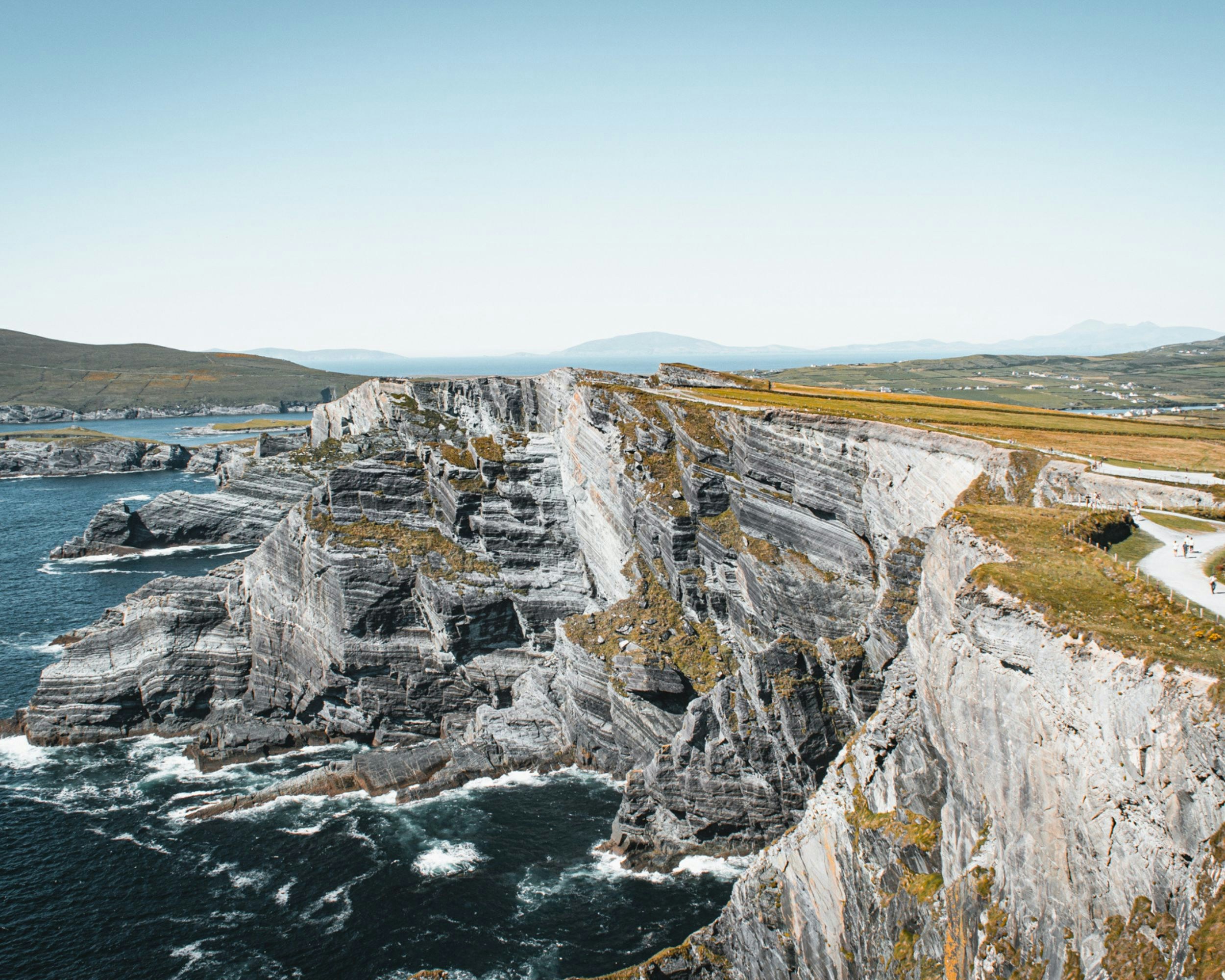 a rocky cliff with a body of water below