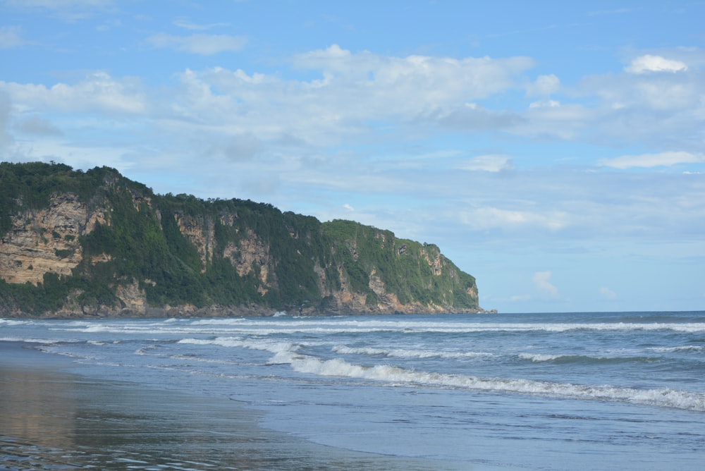 a beach with a hill in the background