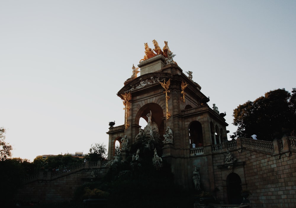 a large stone building with a large archway and statues on top