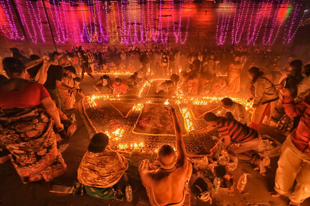 a group of people dancing in a room with a crowd watching