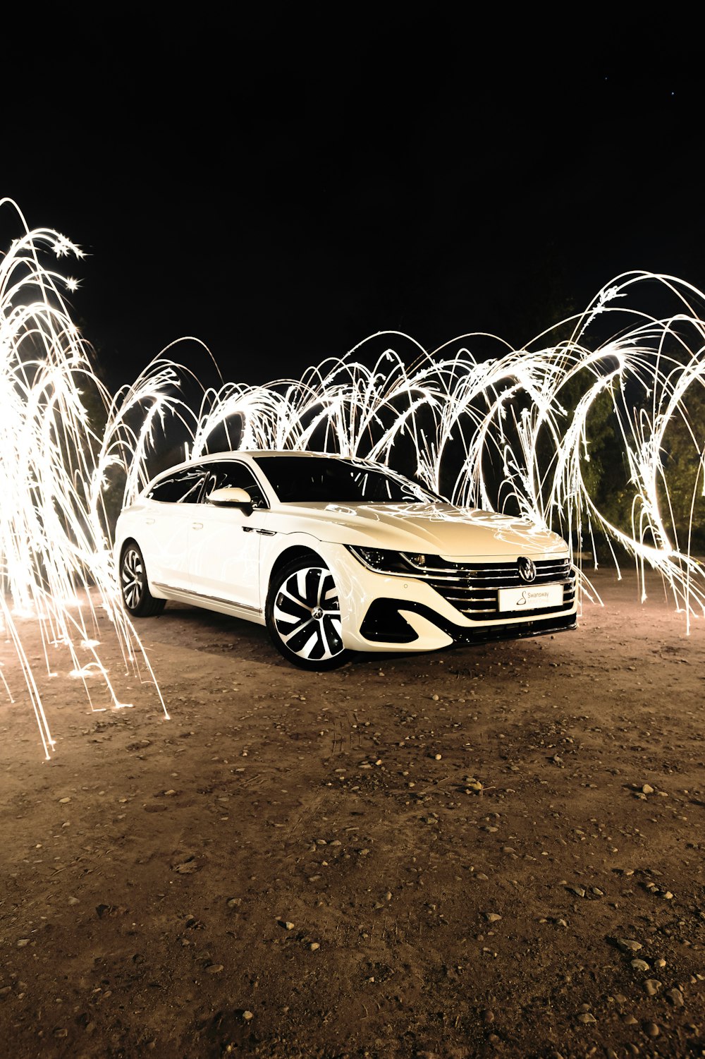 a car parked on a dirt road with sparks coming out of it