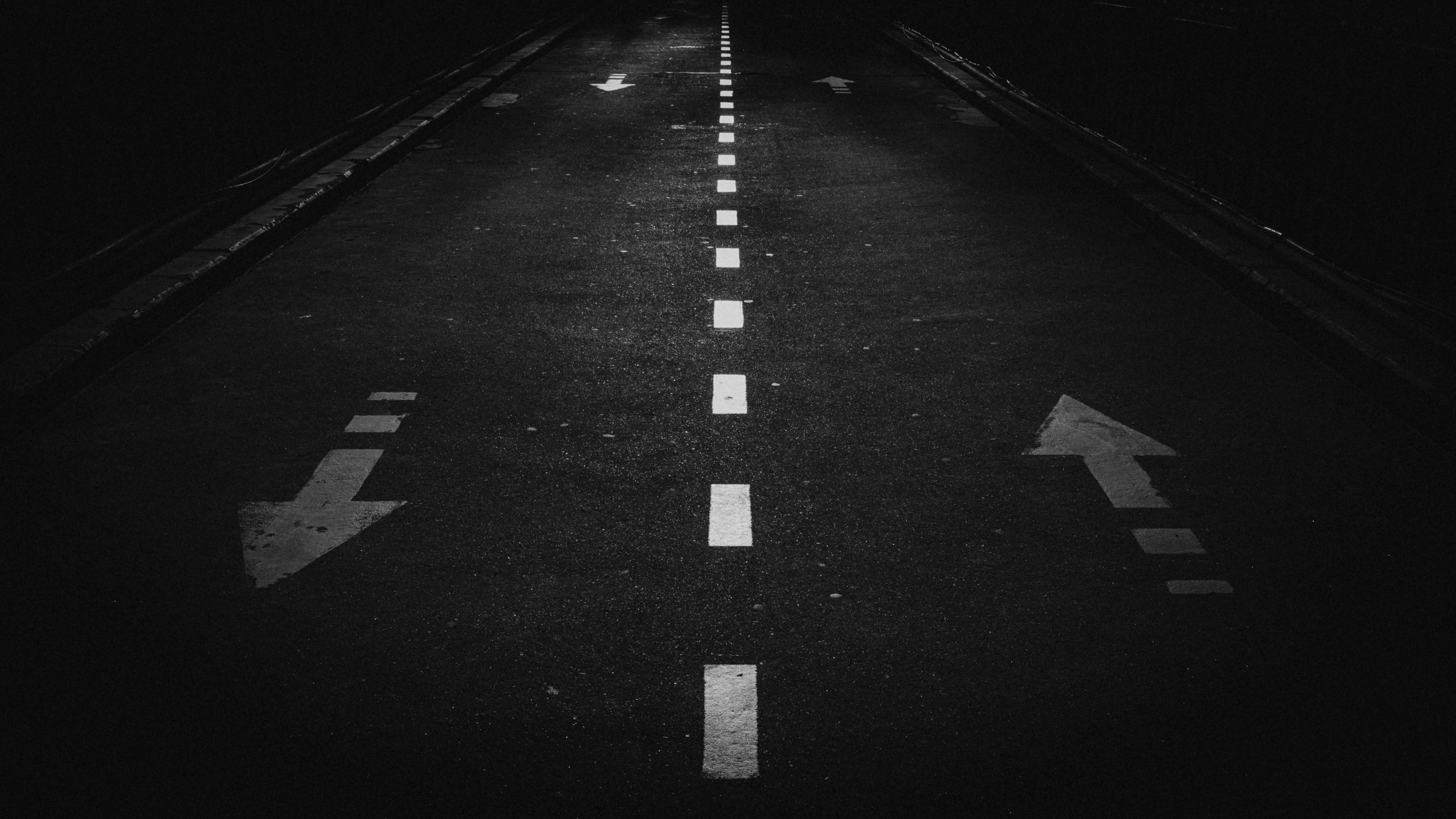 Une route avec des flèches blanches