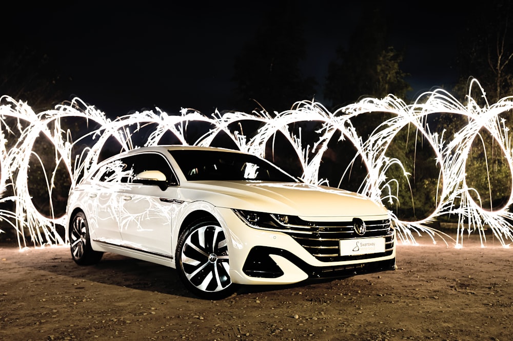 a car parked on a dirt road with fireworks in the background