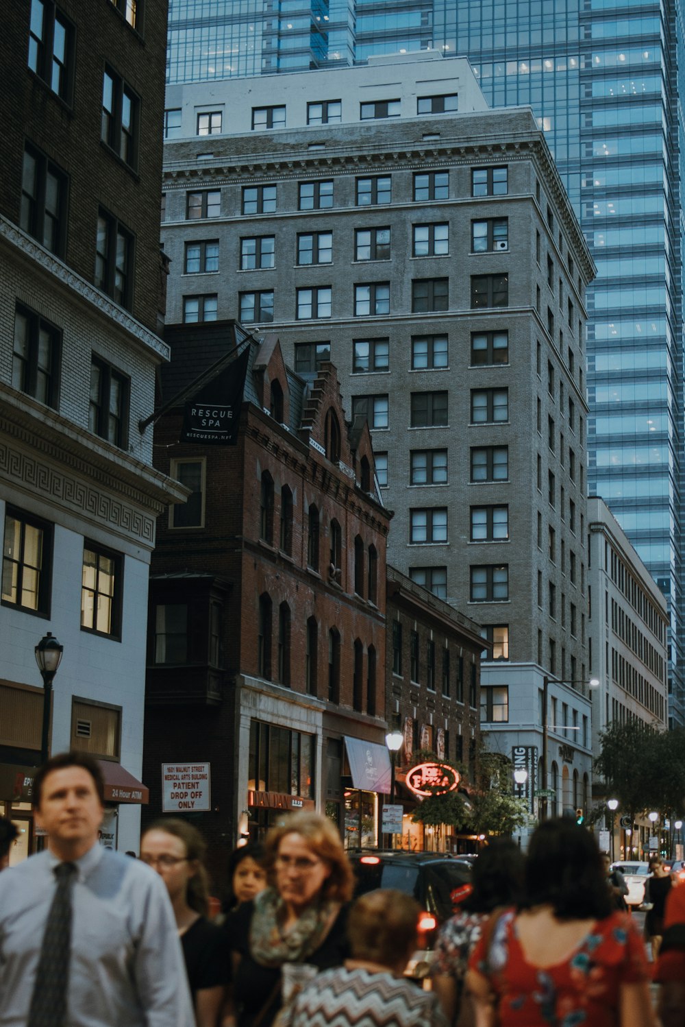 a group of people walking on a street between buildings