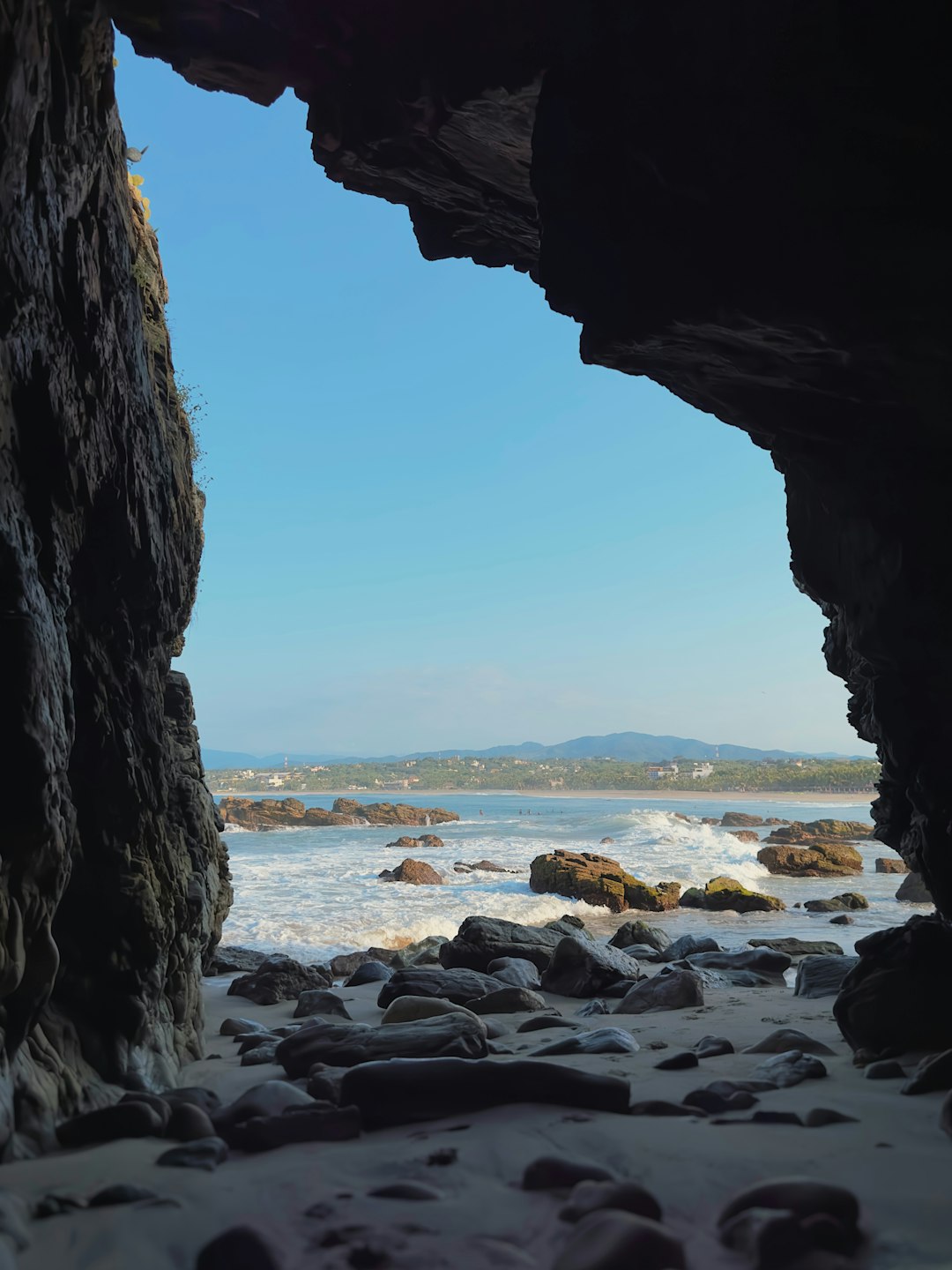 a rocky beach with a large rock arch