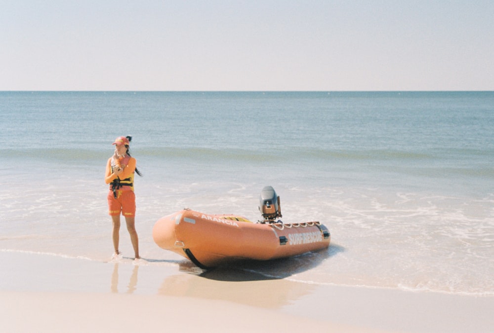 a person standing next to a large sea animal on a beach